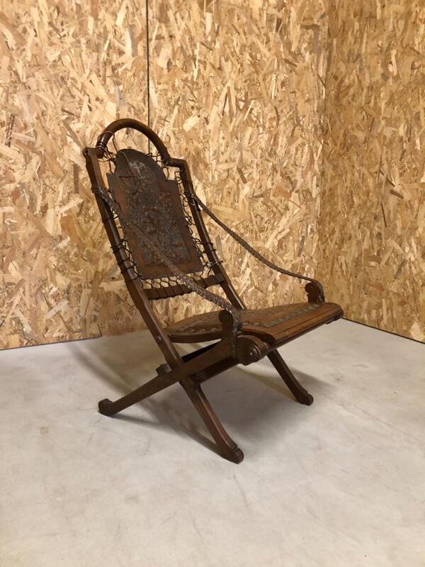 Important fauteuil pliant en bois sculpté et cuir . Vers 1920 